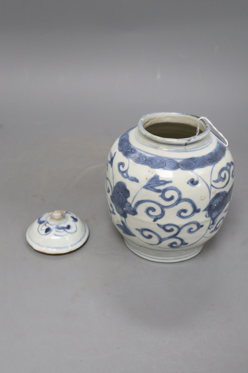 A Chinese Late Ming blue and white lion and lotus jar and cover, overall height 17.5cm, restored rim